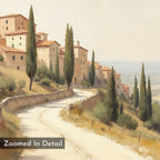 A winding road passes rustic hillside buildings with tall cypress trees, overlooking a sunlit landscape—captured in the Tuscan Village Canvas Art - Horizontal. At the bottom left, a label reads, “Zoomed In Detail.”.