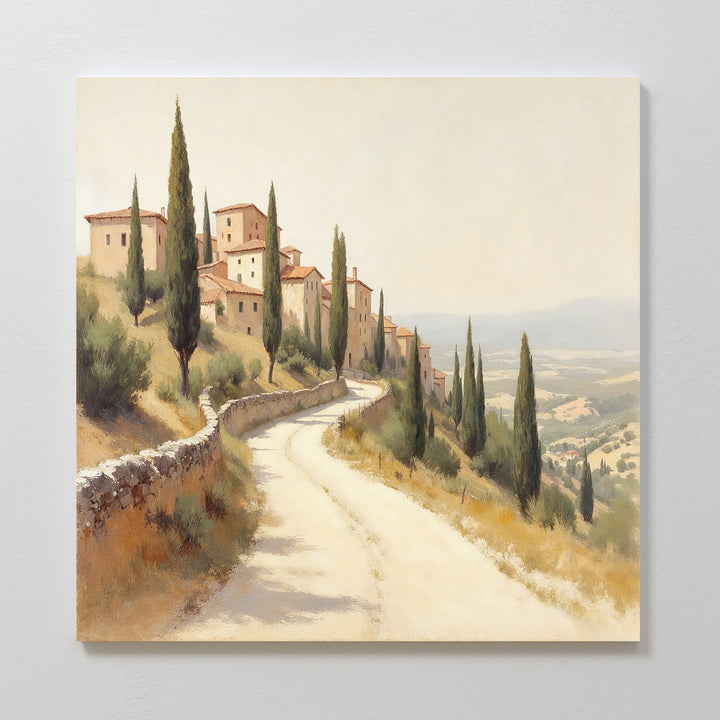 A winding dirt road with cypress trees leads to rustic stone houses, capturing the charm of Tuscany—ideal as the Tuscan Village Canvas Art - Square for adding Mediterranean style to your home décor.