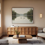 A serene living room features a light wood sideboard, coffee table, beige sofa, and the Twin Swans Serenity Canvas Art - Horizontal as Nordic Park decor. Soft lighting and neutral tones create a cozy atmosphere inspired by nature.