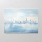 The Urban Mirage Canvas Art - Horizontal features an abstract city skyline with tall buildings reflected on calm water in soft blue, white, and hints of orange—ideal modern decor for your living room.