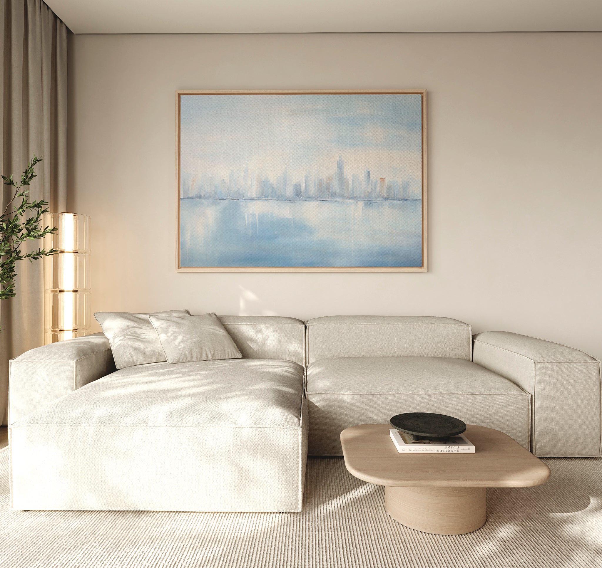 A modern living room with a light beige sectional, low wooden coffee table with black bowl, neutral walls, and the Urban Mirage Canvas Art - Horizontal featuring a soft blue city skyline above the sofa—perfect decor.
