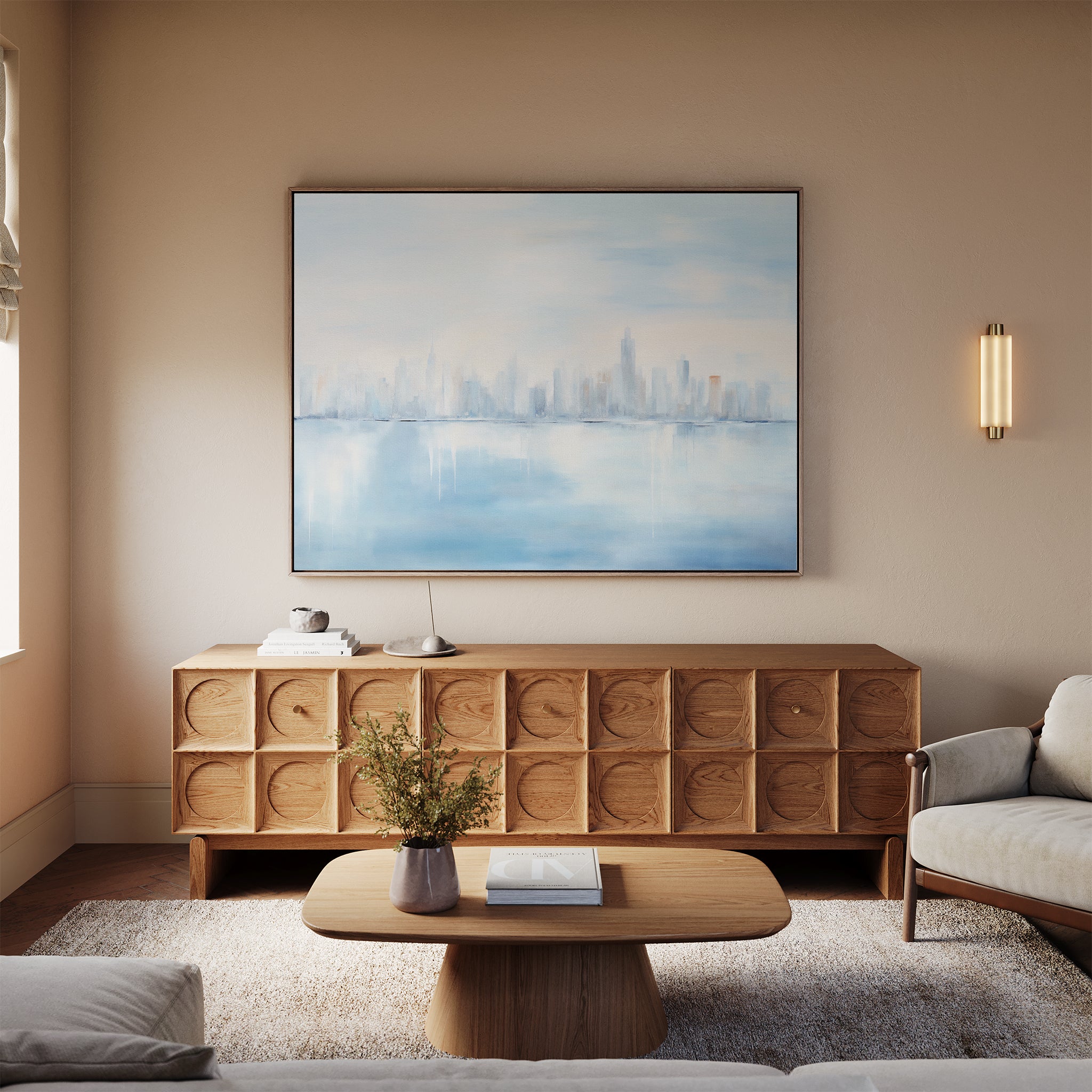 A modern living room with a light wood coffee table, textured sideboard, beige couch, soft lighting, and a vase of flowers is finished with the Urban Mirage Canvas Art - Horizontal for a stylish city skyline decor touch.