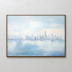 The Urban Mirage Canvas Art - Horizontal features a city skyline reflected on water in soft blue, white, and light gray tones with blurred, impressionistic details—ideal modern décor for any living room.