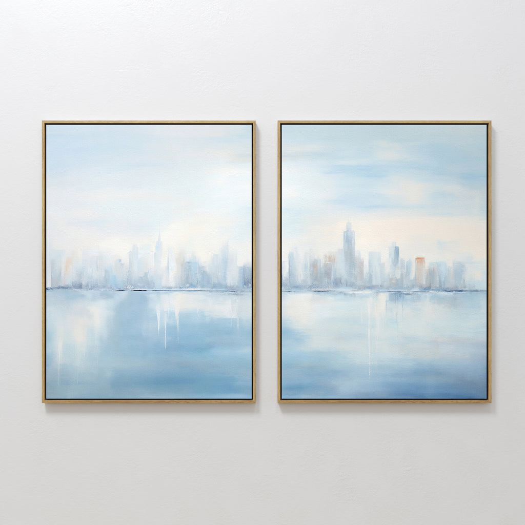 Urban Mirage - Set of 2 features square canvas prints with a soft, abstract city skyline reflected over water in pale blue, white, and peach—ideal wall art for modern living room décor.