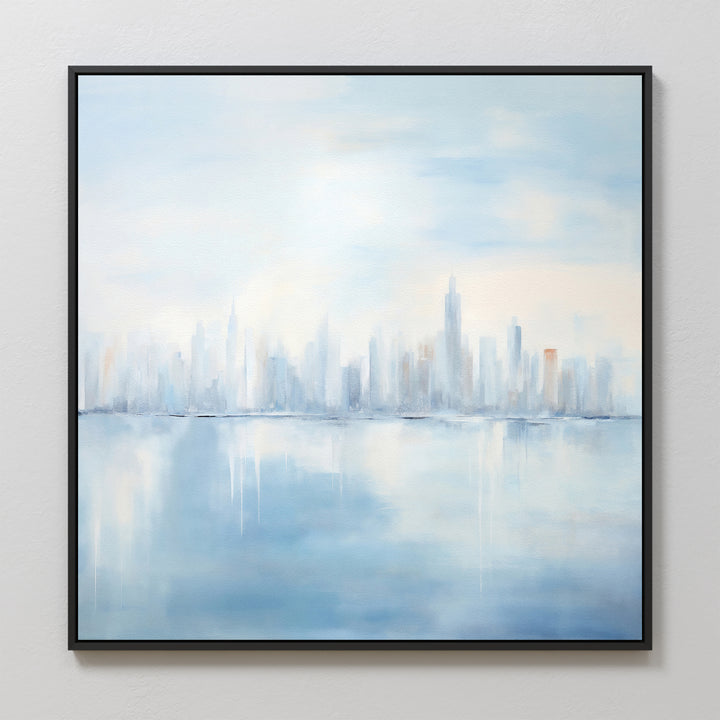 Urban Mirage Canvas Art - Square features a dreamy city skyline with tall buildings reflected on calm water in soft blue, white, and gray tones. Framed in black, it’s ideal modern wall decor for your living room.