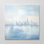 Urban Mirage Canvas Art - Square features a dreamy, abstract city skyline with tall buildings reflected in calm water. Soft blue and gray hues create a serene mood, making it ideal modern wall decor for your living room.