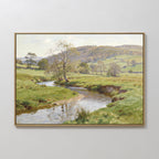 The Valley Stream Canvas Art - Horizontal displays a serene countryside with grassy fields, a winding river, scattered trees, and rolling hills under a partly cloudy sky, beautifully capturing rural charm.
