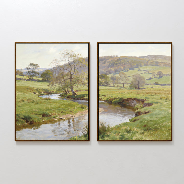 The Valley Stream - Set of 2 features two framed paintings side by side, each showing a tranquil countryside with rolling green hills, trees, and a reflective river winding through grassy meadows beneath a soft sky.