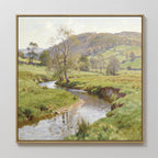 The Valley Stream Canvas Art - Square showcases a framed countryside landscape with a winding river, grassy fields, scattered trees, rolling hills, and a partly cloudy sky.