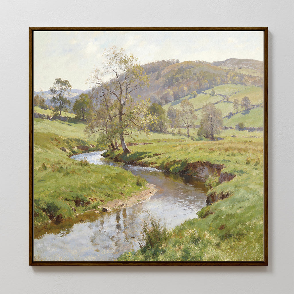 The Valley Stream Canvas Art - Square features a framed serene landscape with a curving river, green banks, scattered trees, rolling hills, and a partly cloudy sky for a peaceful rural vibe.