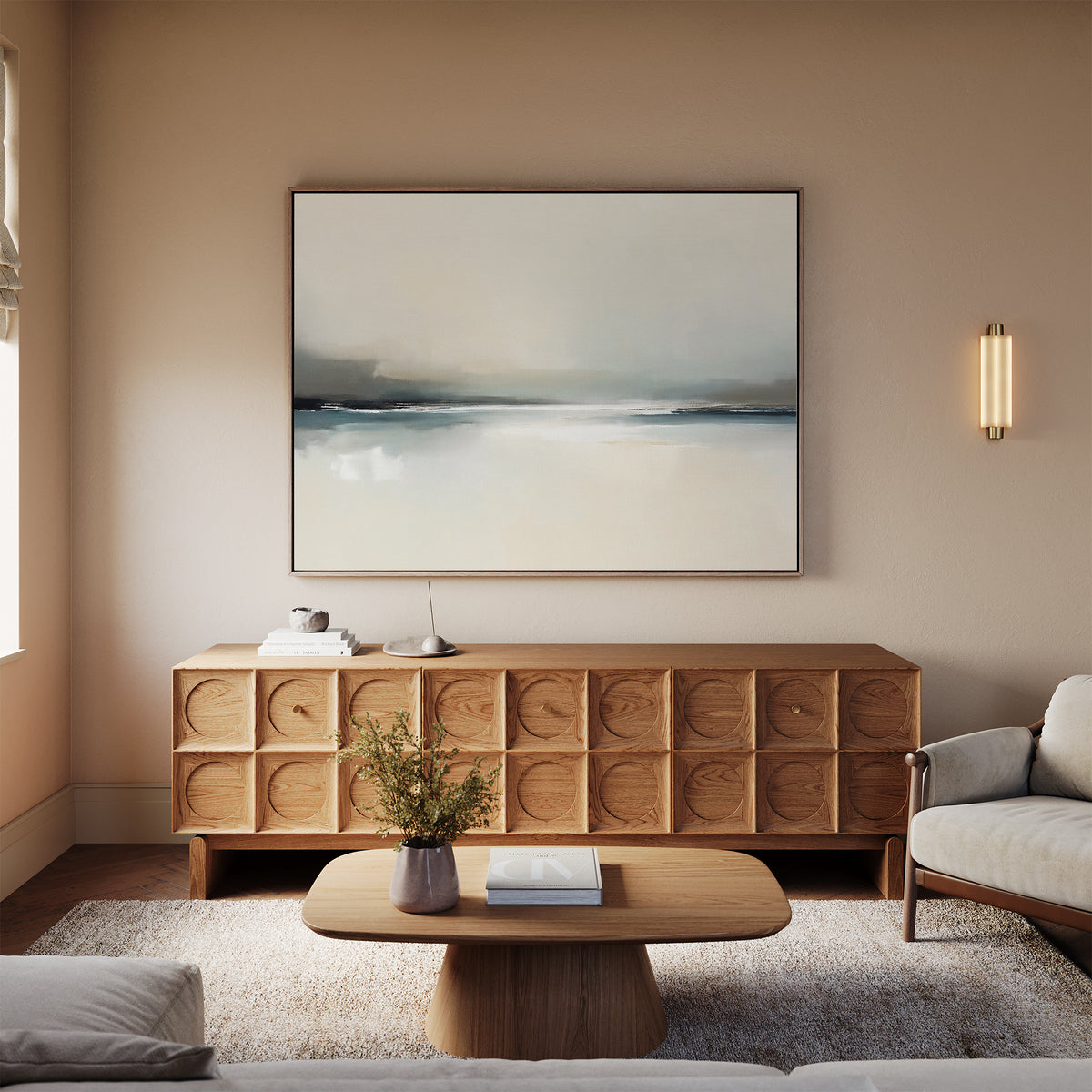 A modern living room with a light beige sofa, wooden coffee table, textured sideboard, minimalist decor, soft lighting, and the Veiled Estuary Canvas Art - Horizontal on the wall creates a calm, cozy atmosphere.
