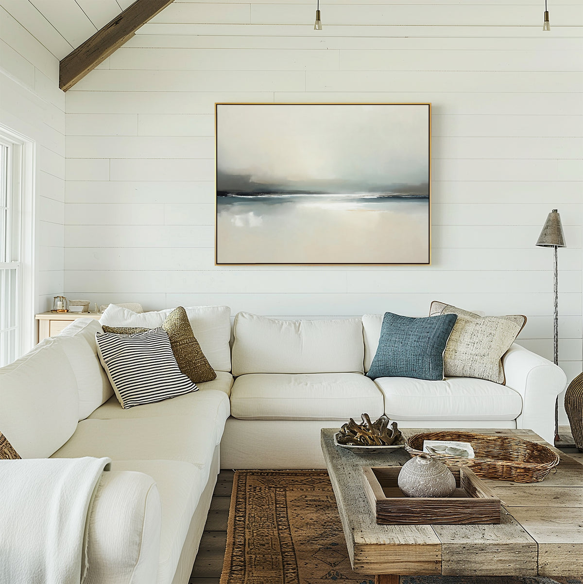 A cozy living room with white shiplap walls, a spacious white sectional sofa adorned with throw pillows, a rustic wood coffee table, and the Veiled Estuary Canvas Art - Horizontal displayed above the sofa.