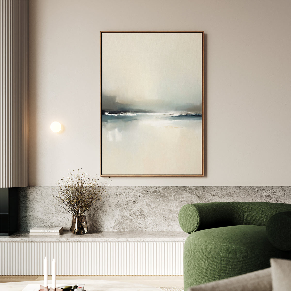 A minimalist living room features the Veiled Estuary Canvas Art - Vertical on the wall, a small round light fixture, a vase with dried branches on a marble ledge, and a green curved upholstered sofa in the foreground.