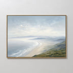 The Veiled Shores Canvas Art - Horizontal features a framed print of a tranquil beach scene with curving sand, distant misty hills, and a gentle cloudy sky—perfect serene coastal wall art for your space.