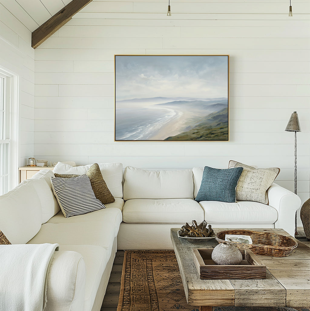 Bright, cozy living room with a white sectional sofa, assorted pillows, a rustic wooden coffee table, and the Veiled Shores Canvas Art - Horizontal on a white shiplap wall. Natural light streams in from the left.