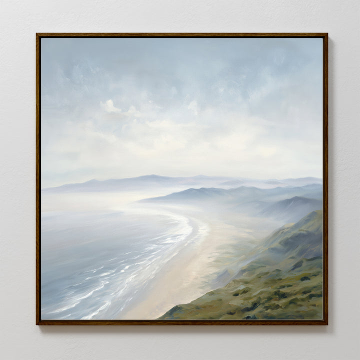 The Veiled Shores Canvas Art - Square showcases a misty coastline with gentle waves, sandy shore, and distant hills beneath a cloudy sky—perfect coastal landscape wall art for any room.