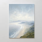 The Veiled Shores Canvas Art - Vertical captures a serene coastline with gentle waves and misty mountains beneath a cloudy sky, creating tranquil wall art perfect for enhancing any space.
