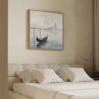 A minimal, beige bedroom with a cushioned headboard, white pillows, and the Venetian Stillness Canvas Art - Square of a gondola on calm water above the bed. A bare branch in a vase brings European charm to the nightstand.