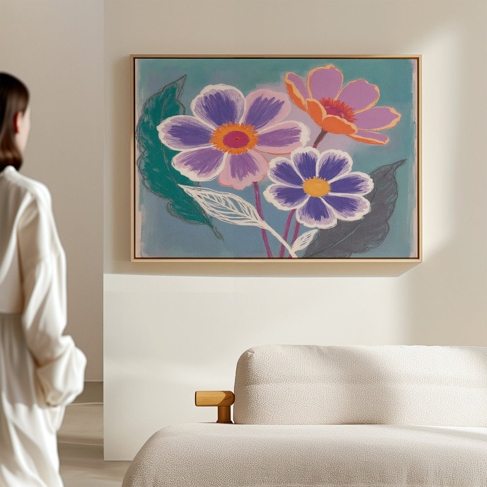 A person in a white robe stands facing a wall where the "Vibrant Petals Canvas Art - Horizontal" hangs above a beige sofa in a bright, minimalistic room.