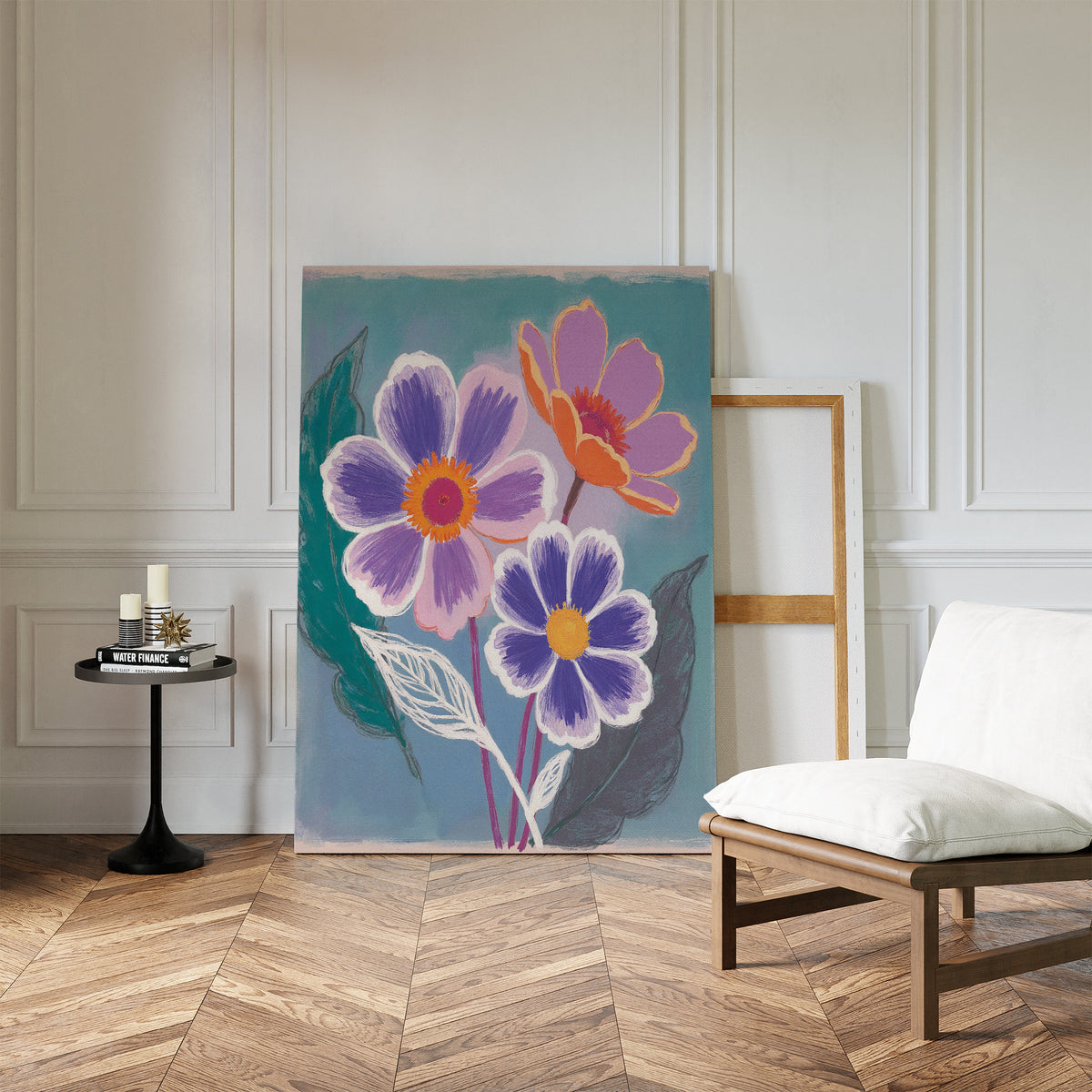 The Vibrant Petals Canvas Art - Vertical, featuring three flowers with purple, orange, and pink petals, leans against a white paneled wall in a bright room with wood flooring, a modern white chair, and a black side table.