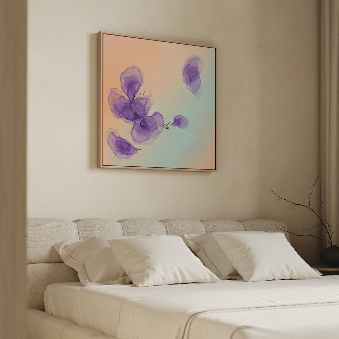 A modern bedroom with a beige upholstered bed and white pillows features the Violet Dreams Canvas Art - Square above the headboard, showcasing petal-like shapes and adding botanical charm to the soft, neutral décor.