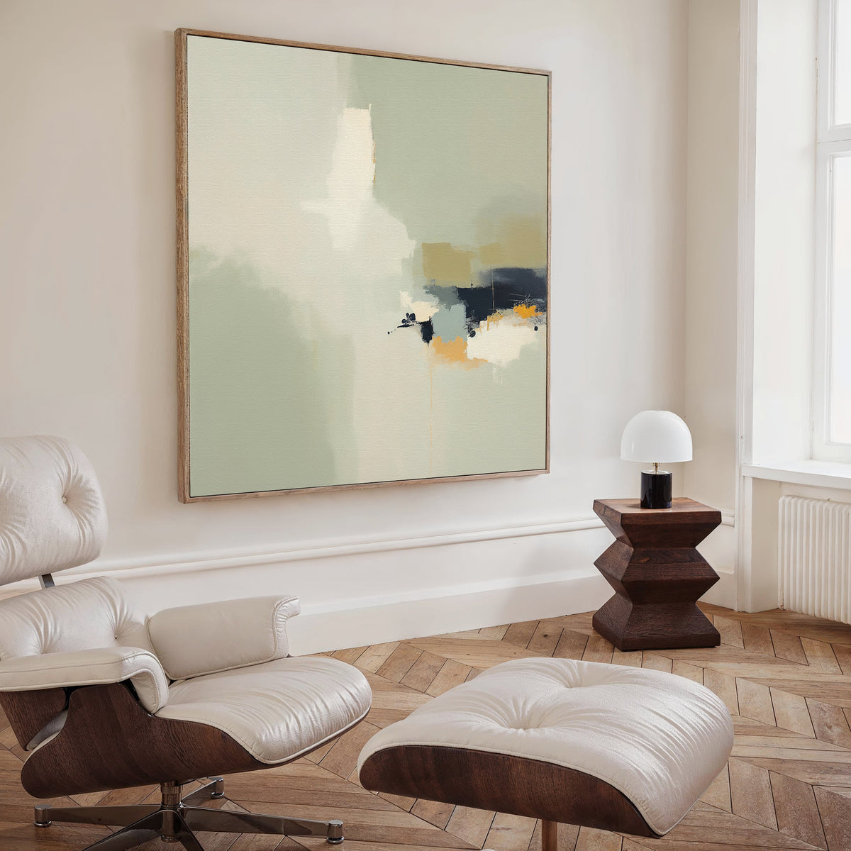 A modern living room with Weathered Composition Canvas Art - Square on the wall, a white leather lounge chair and ottoman, a geometric wooden side table, small lamp, and herringbone wood floors exudes modern elegance.