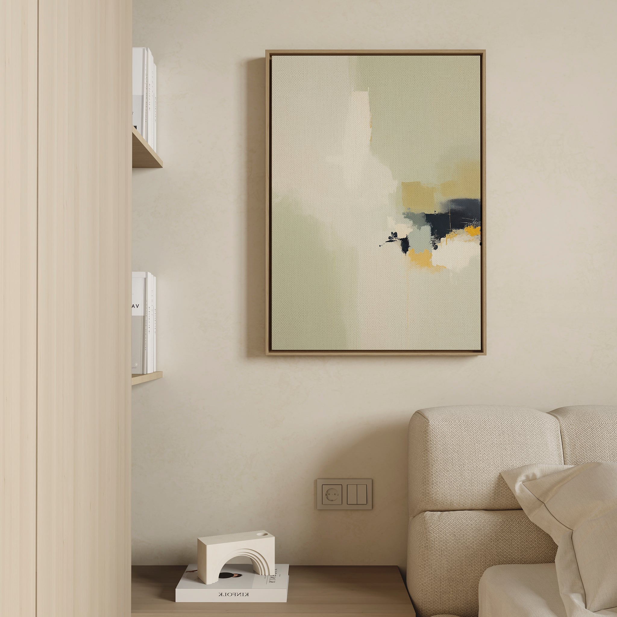 A minimalist living room corner with a beige sofa, a chic white decor piece, books on wall shelves, and the Weathered Composition Canvas Art—an abstract vertical painting in neutral tones with subtle black and yellow accents.