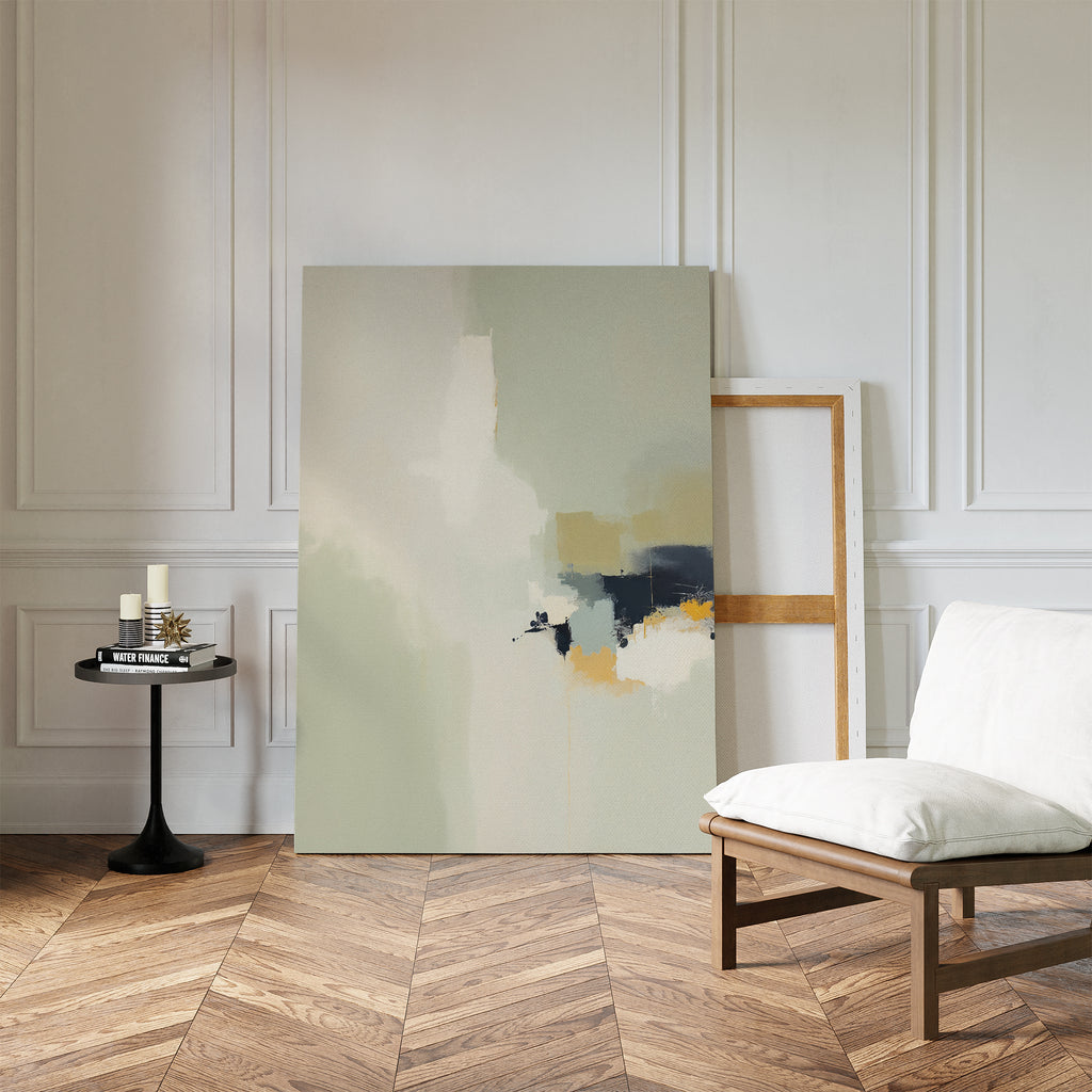 A minimalist living space features a white cushioned chair, a round black side table with candles and books, and the Weathered Composition Canvas Art - Vertical resting against a paneled white wall on a parquet wood floor.