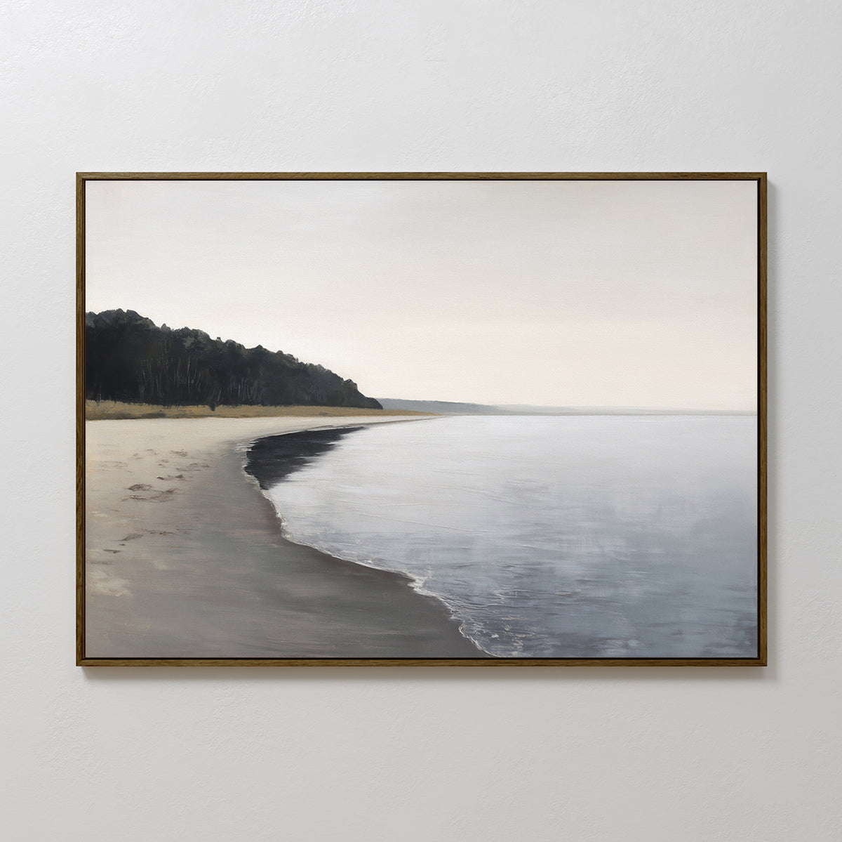 The Weathered Shore Canvas Art - Horizontal features a tranquil, minimalist view of a calm beach, gentle waves, a forested headland on the left, and an overcast sky—perfect serene wall art for coastal decor lovers.