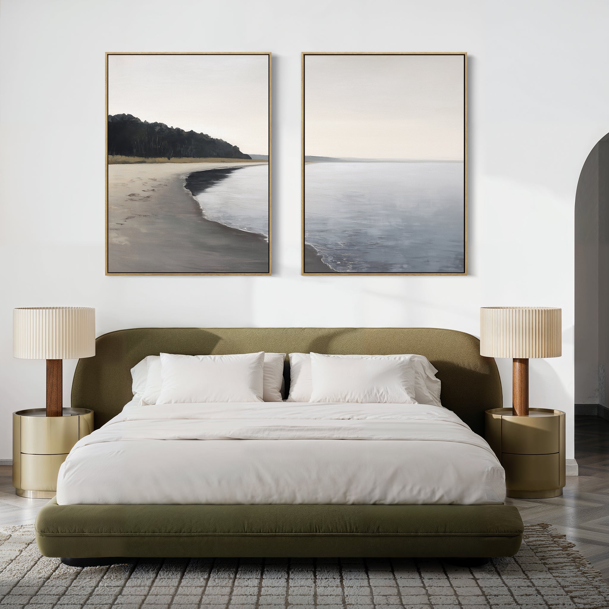 A modern bedroom features a low olive-green bed with white bedding, two round gold nightstands topped with beige lamps, and the "Weathered Shore - Set of 2" shoreline wall art pieces displayed above the headboard.