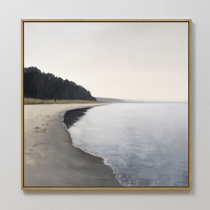 The Weathered Shore Canvas Art - Square features a calm, empty beach with gentle waves and distant trees under a soft, cloudy sky, creating a serene coastal atmosphere for your space.