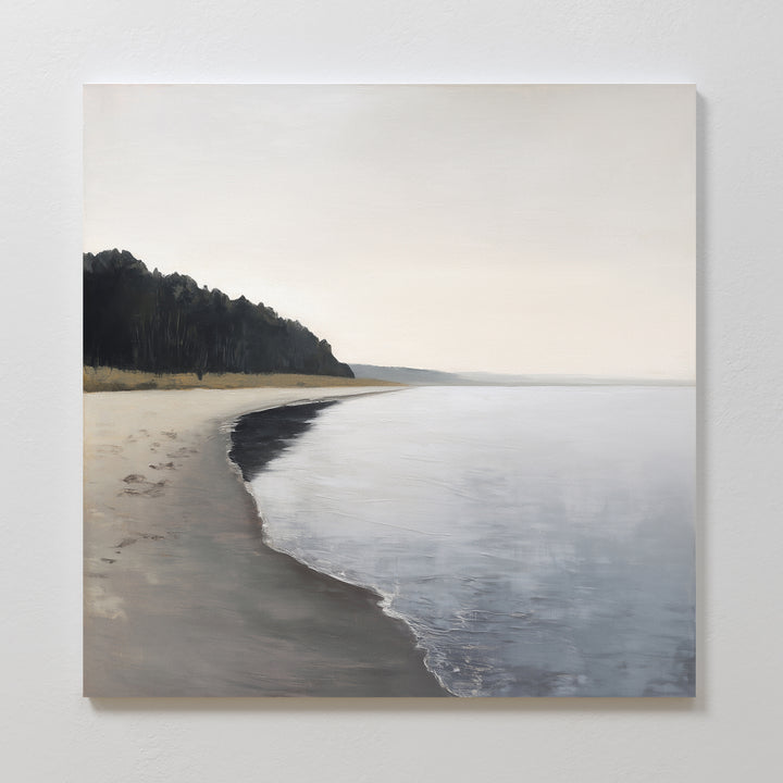 The Weathered Shore Canvas Art - Square captures a calm, empty beach with gentle waves, sandy shore, and a dark tree line under a pale sky—ideal shoreline wall art for anyone seeking tranquil coastal canvas prints.