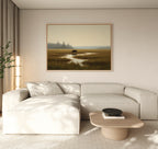 A modern living room featuring a light beige sectional sofa, wooden coffee table with a black bowl, tall plant, and the Wetland Bear Canvas Art - Horizontal depicting serene river and fields. Neutral tones and natural light create a tranquil atmosphere.