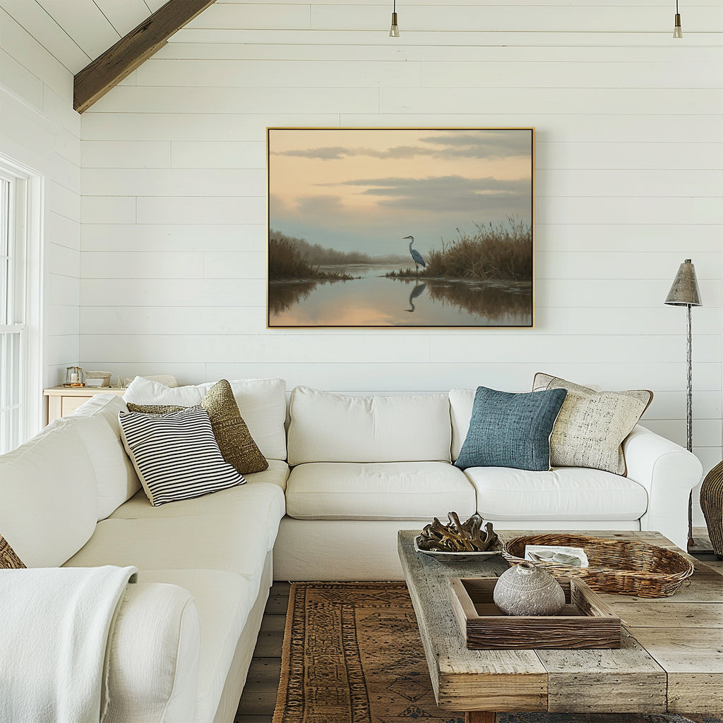 A bright, cozy living room with a white sectional sofa, assorted pillows, a rustic wooden coffee table, and the Wetland Heron Canvas Art - Horizontal featuring a marsh landscape decor on the shiplap wall.