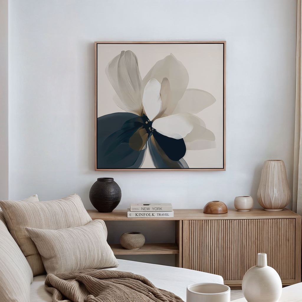 A modern living room features a beige sofa, decorative cushions, wooden sideboard, ceramic vases, stacked books, and the Whispering Petals Canvas Art as the centerpiece of the decor.