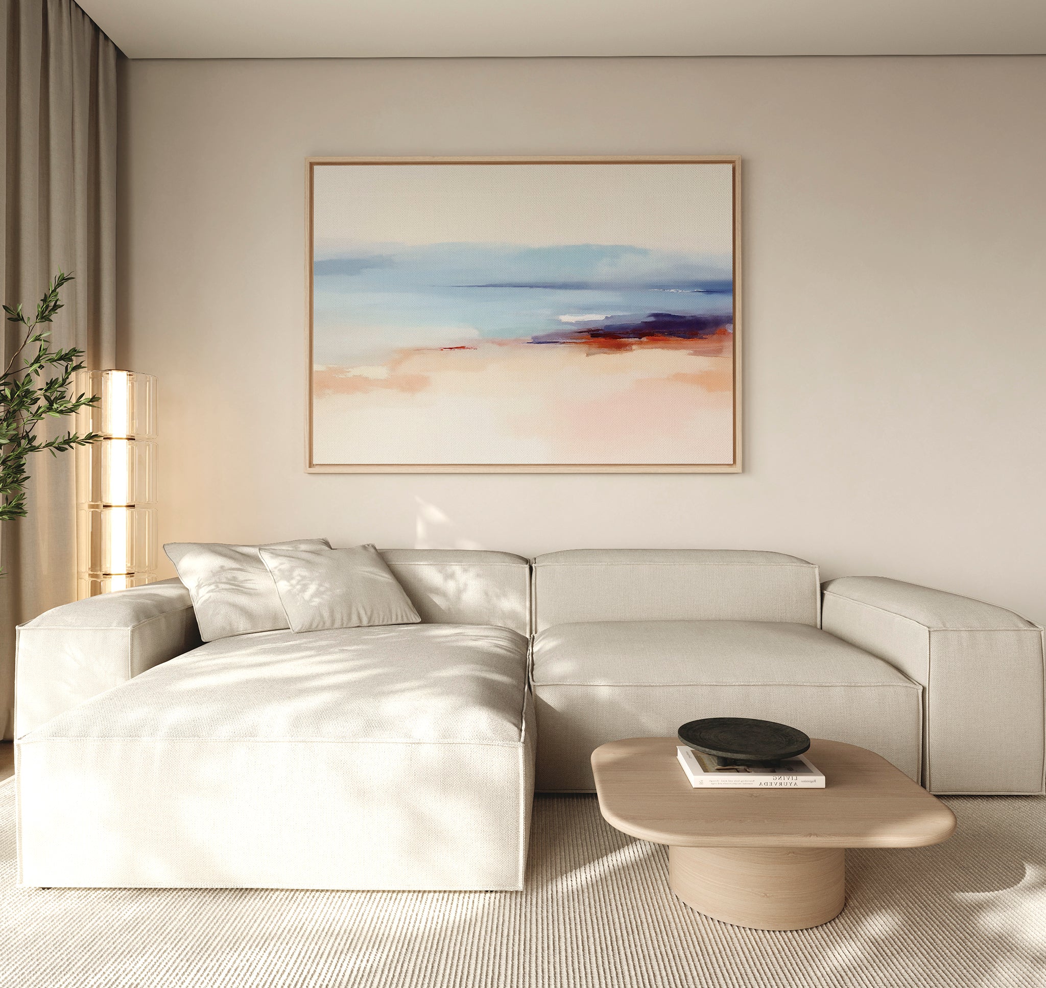 A modern, minimalist living room with a beige sectional, light wood coffee table with a black bowl, tall plant, neutral walls and curtains, and the Windswept Coastline Canvas Art - Horizontal on the wall.