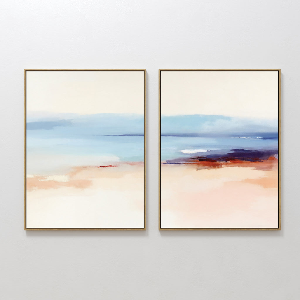 The "Windswept Coastline - Set Of 2" features framed abstract art in soft blues, beige, peach, and red accents, evoking serene Nordic coastal landscapes and creating a tranquil vibe when displayed together on a white wall.
