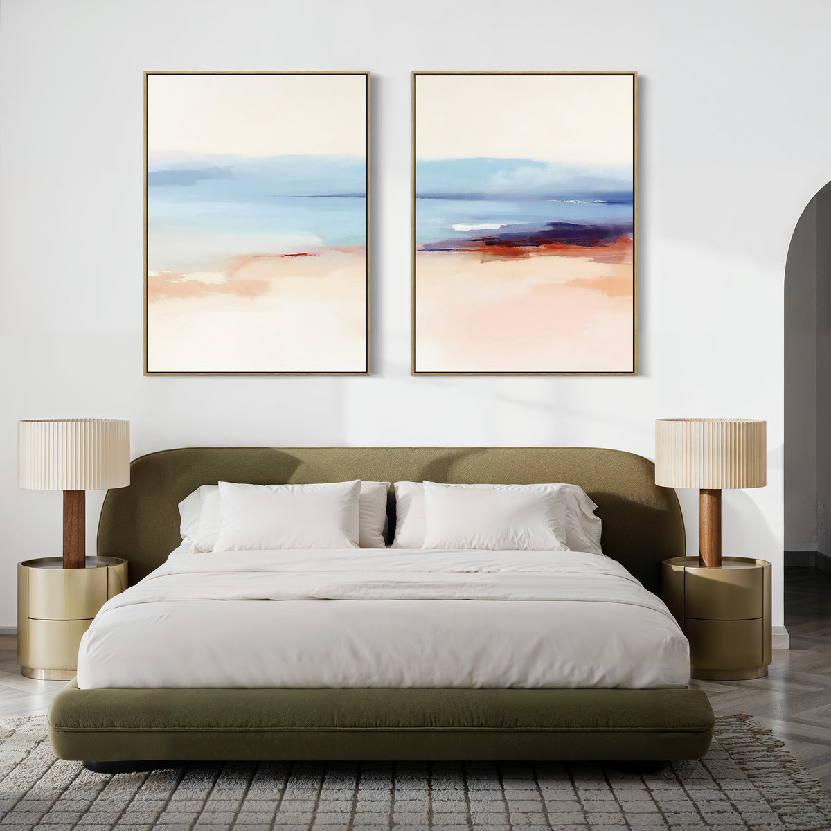 A modern bedroom featuring an olive green upholstered bed with white bedding, two beige nightstands and matching lamps, and the "Windswept Coastline - Set Of 2" serene pastel wall art above the bed.