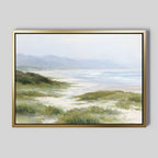 Windswept Dunes Canvas Art - Horizontal features a serene coastal landscape with grassy dunes, a sandy beach, gentle ocean waves, and distant mountains beneath a soft, hazy sky.