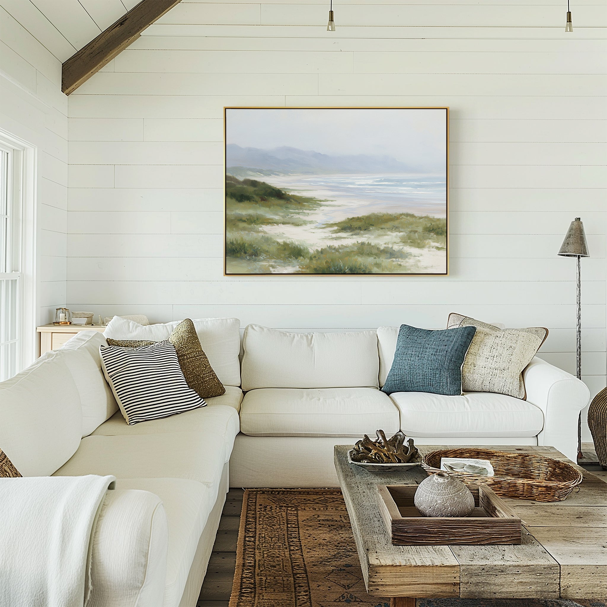 A bright living room with white shiplap walls, a white sectional sofa with pillows, a rustic wood coffee table, and a soothing atmosphere highlighted by the Windswept Dunes Canvas Art - Horizontal above the sofa.