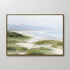 The Windswept Dunes Canvas Art - Horizontal features grassy sand dunes, a sandy shore, gentle waves, and distant hazy mountains beneath a light cloudy sky—ideal for adding a tranquil touch to any space.