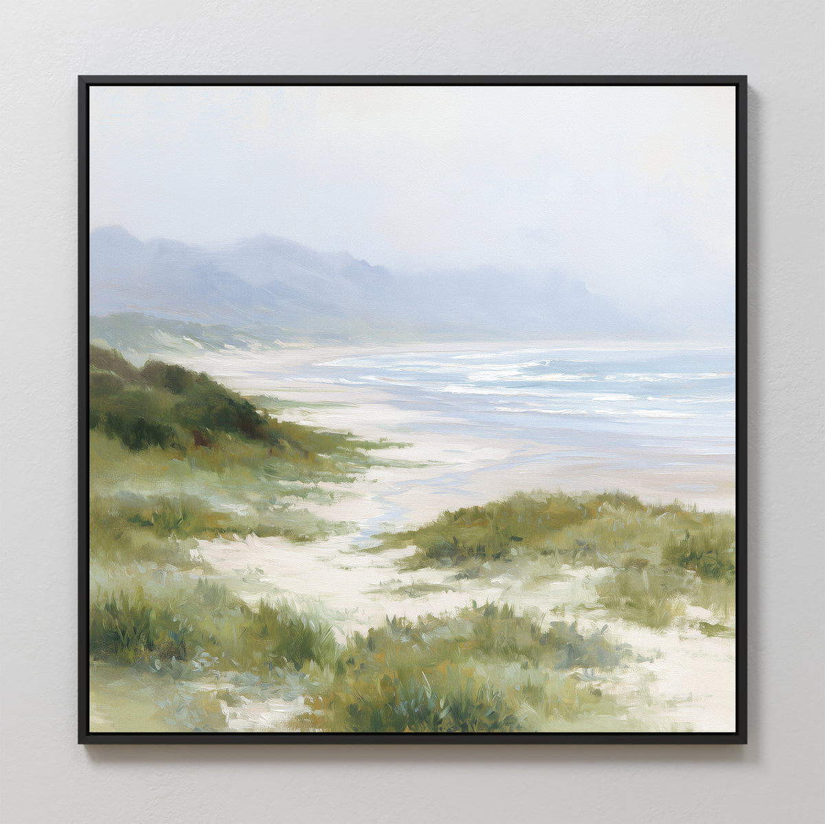 The Windswept Dunes Canvas Art - Square features a serene coastal landscape with green dunes, grasslands, sandy beach, gentle waves, and misty mountains beneath a soft, cloudy sky.