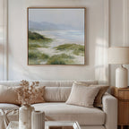 A cozy living room features a beige sofa, cream pillows, and a side table with a lamp. A vase of dried flowers adds charm, while the Windswept Dunes Canvas Art - Square brings a calming touch above the sofa.