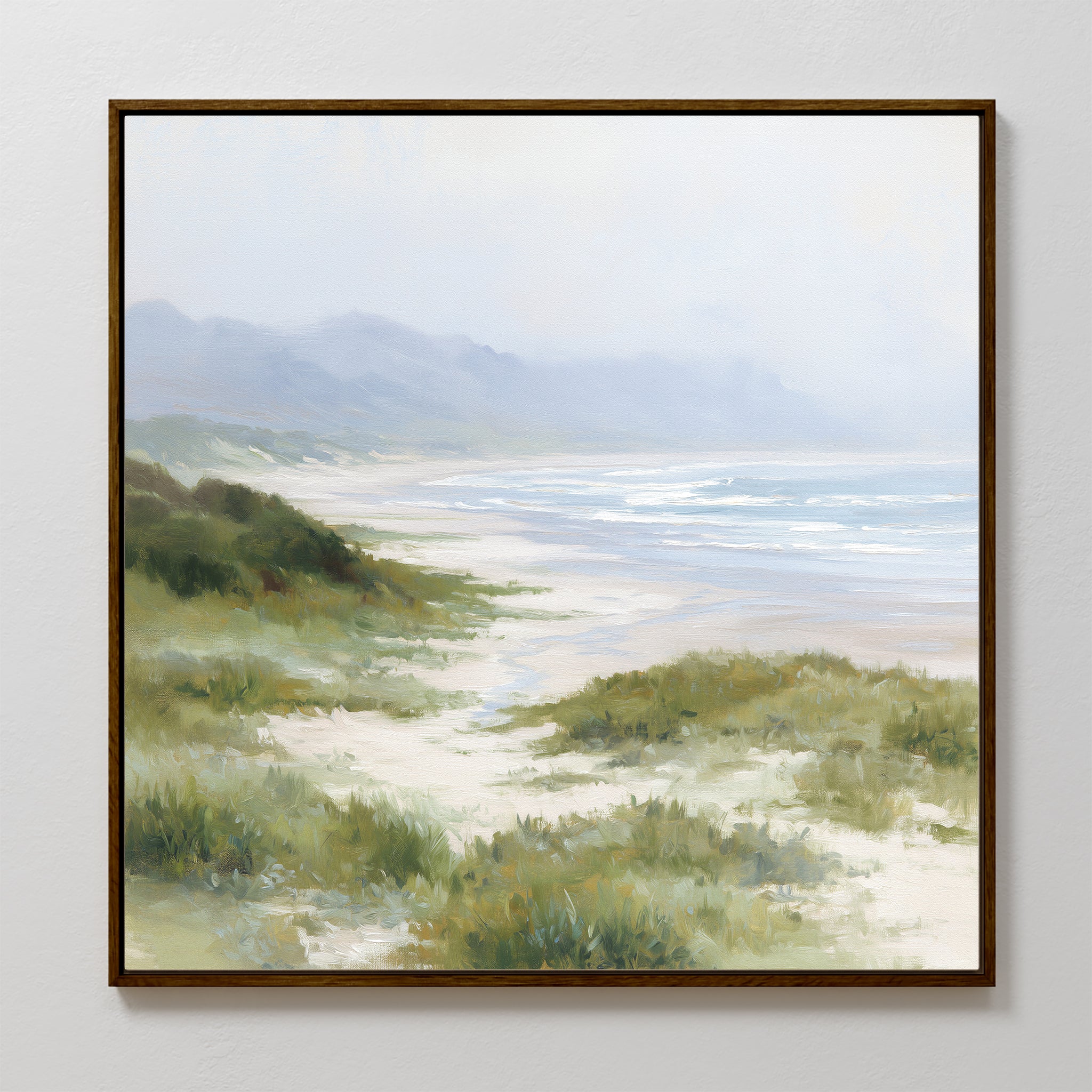 Windswept Dunes Canvas Art - Square: A framed canvas print showcasing serene sandy dunes, lush grasslands, gentle waves, and misty hills beneath a cloudy sky—ideal for bringing a calming atmosphere to any room.