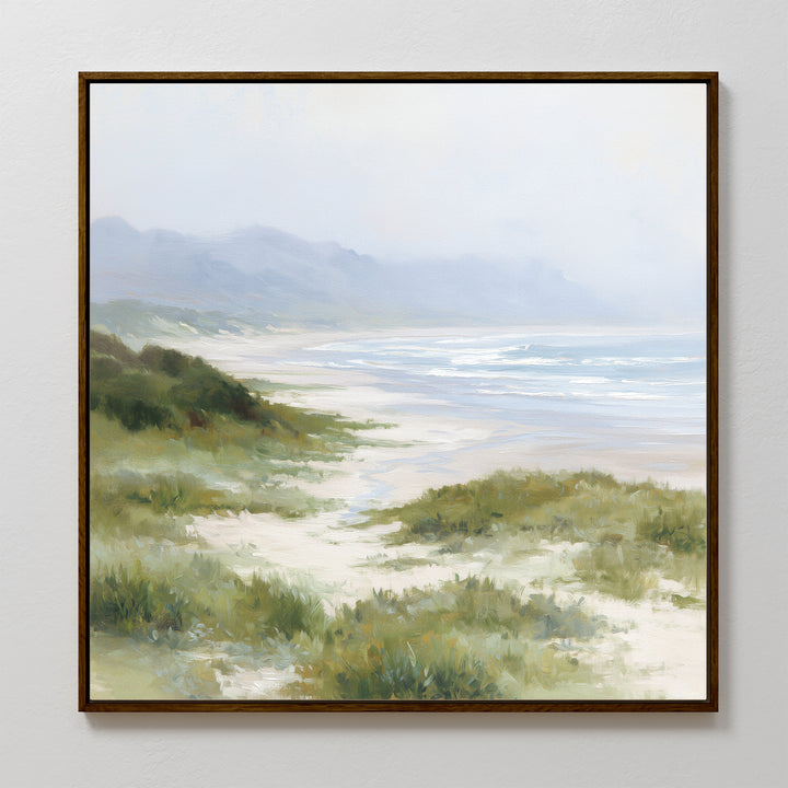 Windswept Dunes Canvas Art - Square: A framed canvas print showcasing serene sandy dunes, lush grasslands, gentle waves, and misty hills beneath a cloudy sky—ideal for bringing a calming atmosphere to any room.