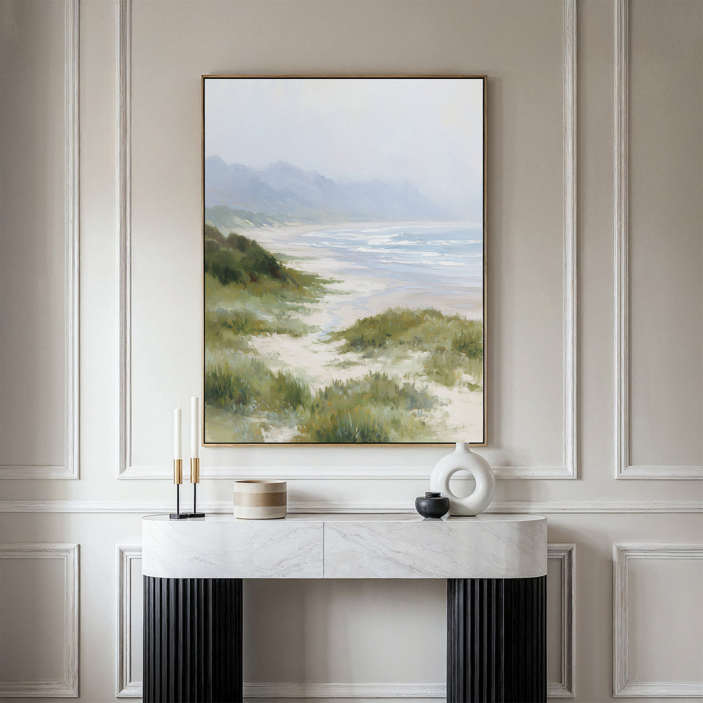 The Windswept Dunes Canvas Art - Vertical hangs above a marble console table adorned with candles, a round container, and modern decor, set against an elegant, light-colored paneled wall.