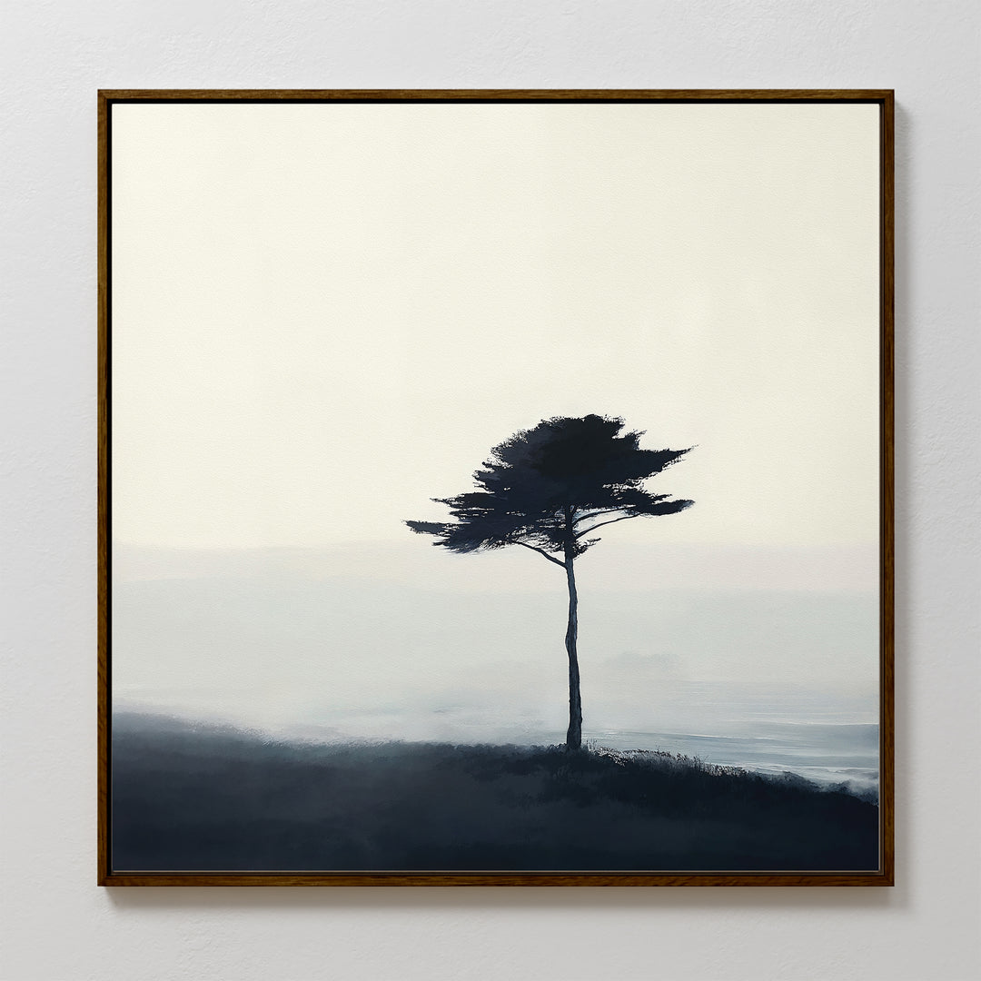 The Windswept Solitude Canvas Art - Square showcases a minimalist lone tree atop a misty hill in soft blue and gray, making it an ideal moody accent for modern living room decor.