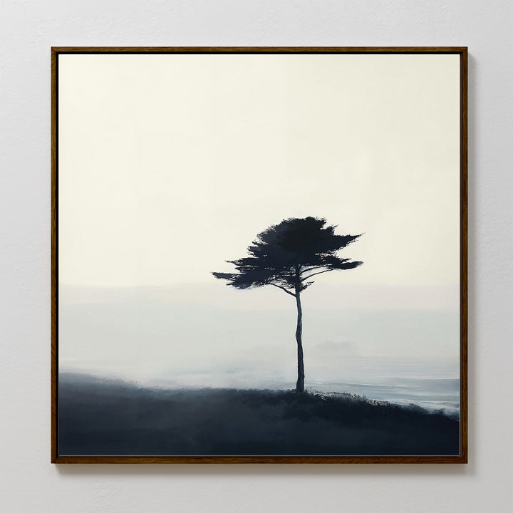 The Windswept Solitude Canvas Art - Square showcases a minimalist lone tree atop a misty hill in soft blue and gray, making it an ideal moody accent for modern living room decor.