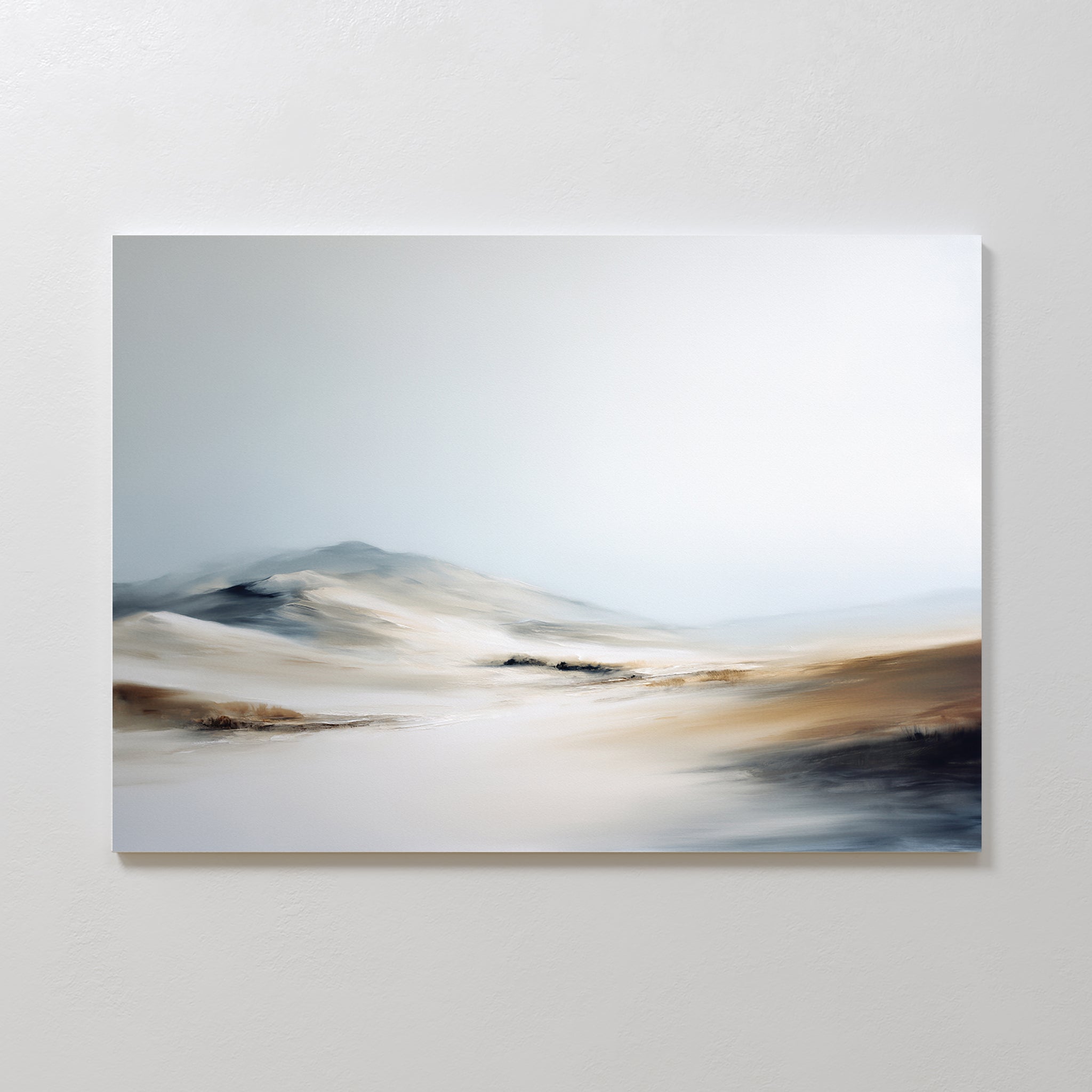 Winter Plains Canvas Art - Horizontal features a minimalist, blurred desert landscape with gentle dunes and soft hills beneath a pale, cloudy sky, adding serene style when displayed on a white wall.