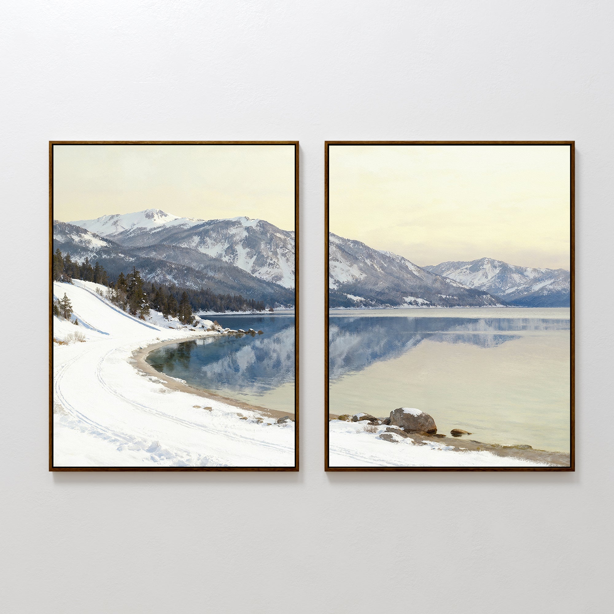 Winter Reflection - Set of 2: These framed prints feature snowy mountains reflected in an alpine lake beneath a soft yellow sky, with snow-covered ground, shoreline curves, and trees on the left—an elegant winter wall art set.